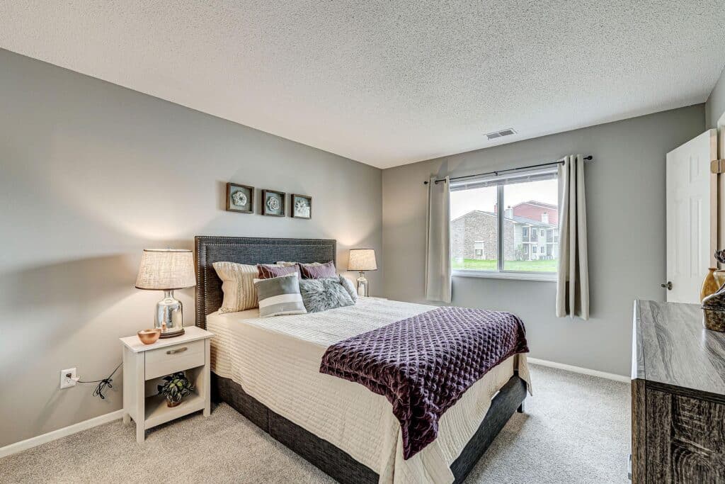 A bedroom with a bed and a window.